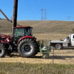Merjent tractor and flatbed truck on high voltage electric transmission right of way (ROW) for site habitat restoration project.