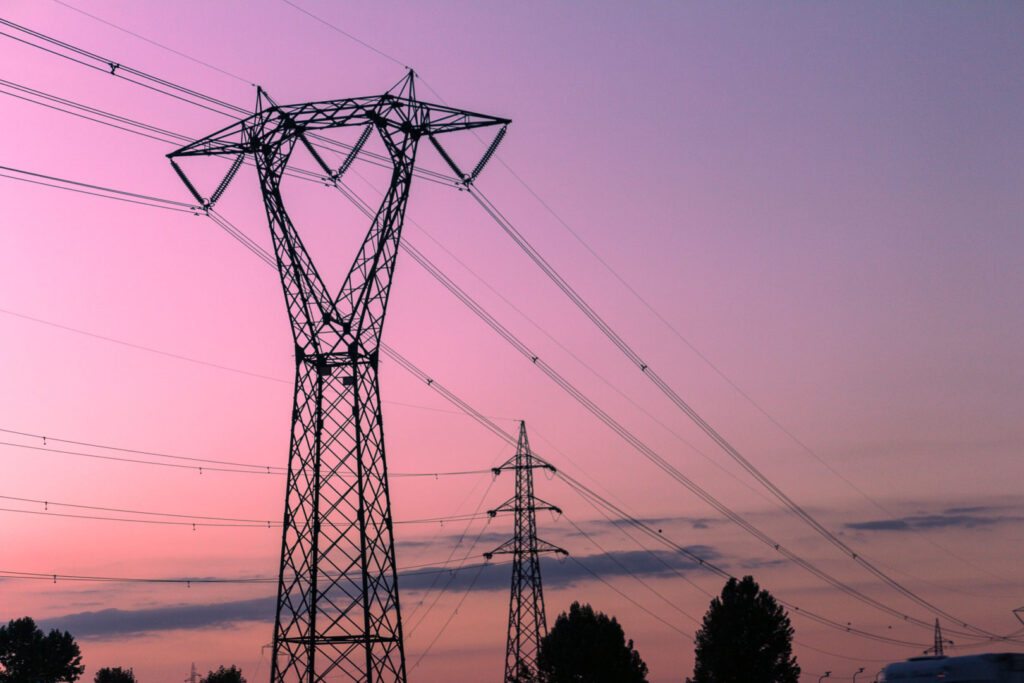 High voltage electric transmission power lines at sunset.