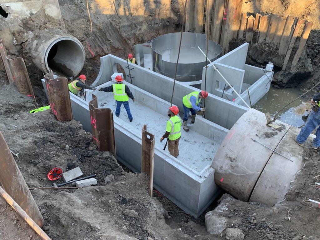 A crew installs storm sewer, stormwater drainage, as part of urban infrastructure project located in Minnesota. The 72" storm sewer was intercepted and routed to a water quality treatment system. Photo taken by Josh Petersen, President Merjent Engineering Division.